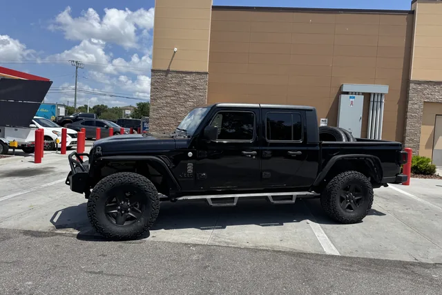 A black Jeep Gladiator on a lift kit and black wheels