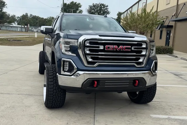 A dark GMC Sierra on a seven inch lift with 24 by 14 wheels on 35s